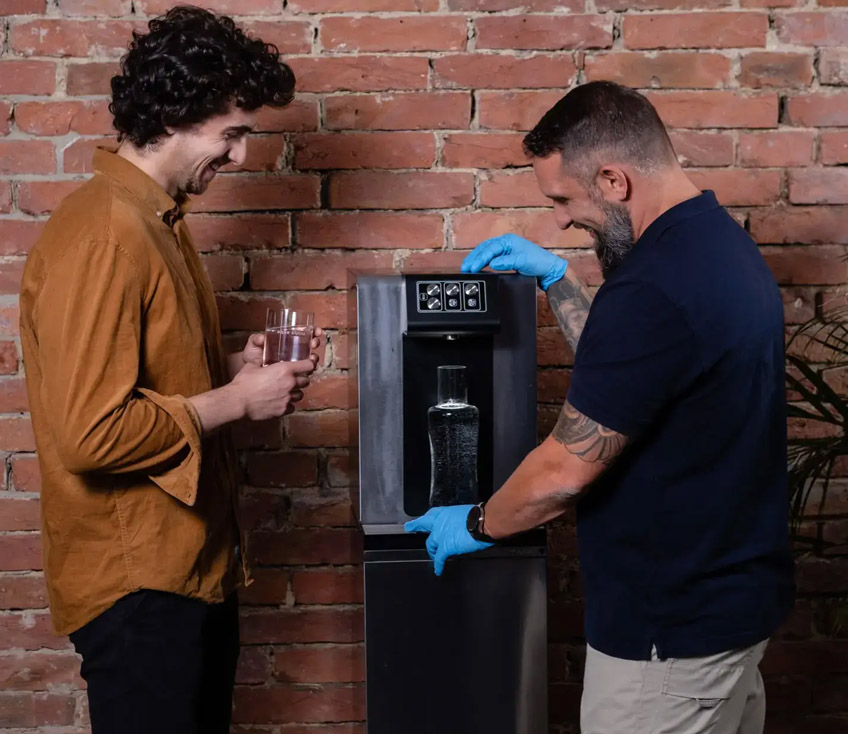 Culligan Techniker erklärt Wasserspender und hat Wasserkaraffe